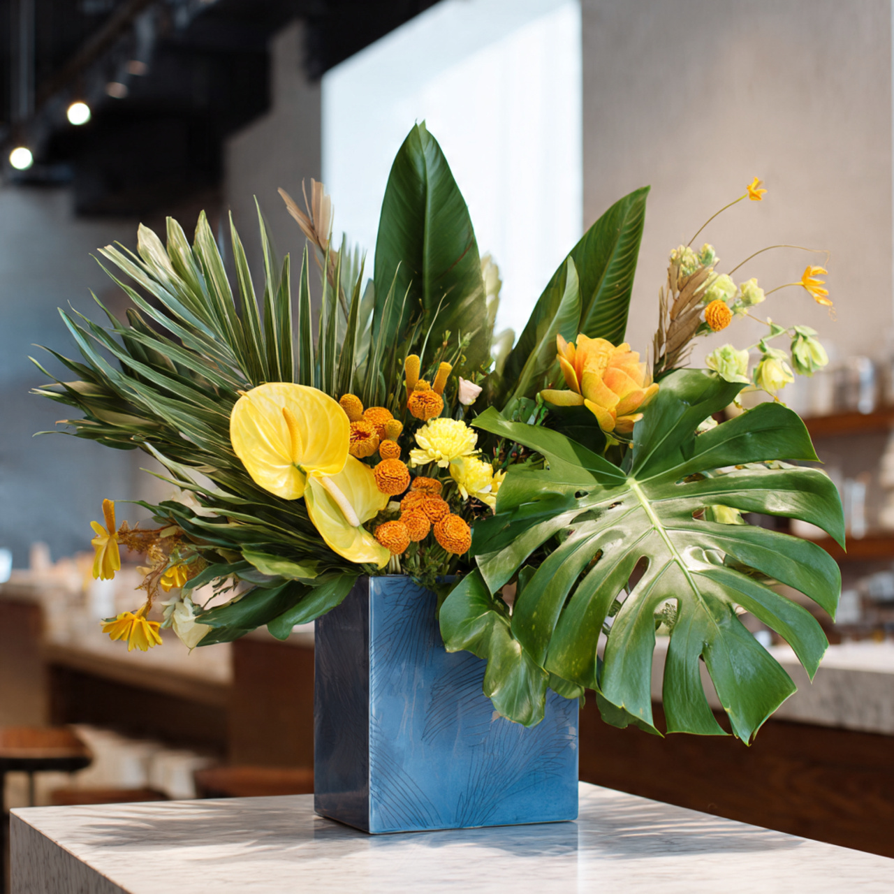 floral arrangement with large monstera banana leaves